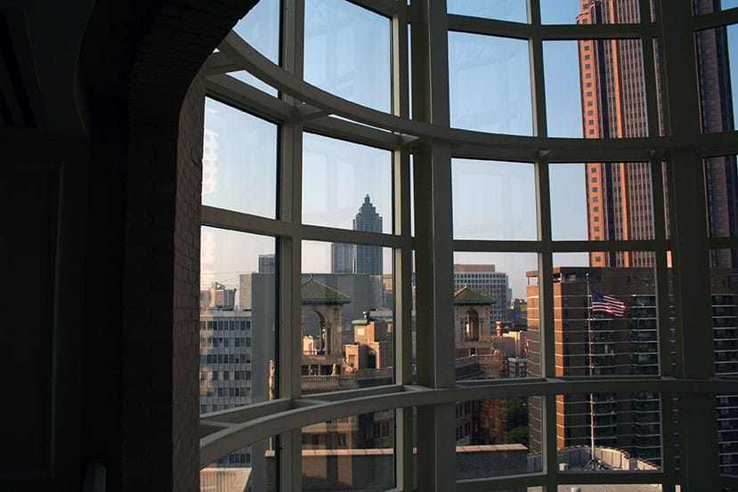 Large office window shows view of Atlanta Georgia city’s skyline during daytime
